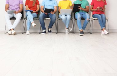 Grup alışveriş torbaları Divan ışık duvarının yakınında oturan olan genç kadın