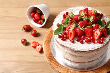 Ahşap masa üzerinde taze çilek ile lezzetli ev yapımı kek