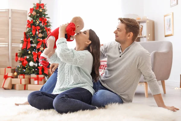 クリスマスの帽子を自宅で赤ちゃんと幸せなカップル — ストック写真