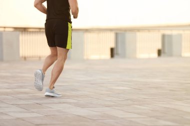 Açık havada güneşli günde koşan genç adam