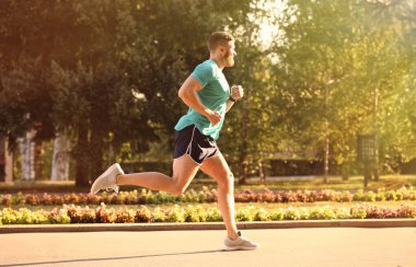 Güneşli günde Park'ta koşan genç adam