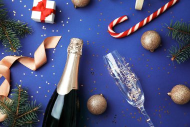 Noel bileşimi ile şişe şampanya, cam ve dekor mavi arka plan, üstten görünüm