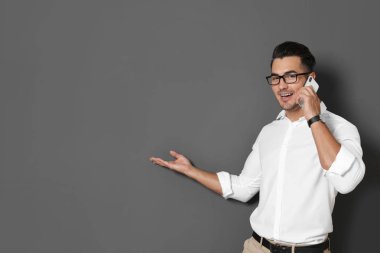 Siyah arka plan karşı telefonda konuşurken yakışıklı delikanlı. Metin için yer