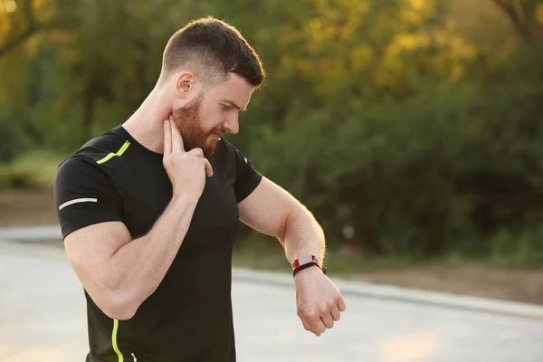 Giovane Uomo Che Controlla Polso Dopo Allenamento Nel Parco — Foto Stock