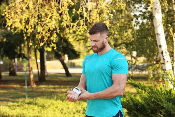 Giovane Uomo Che Controlla Polso Dopo Allenamento Nel Parco — Foto Stock