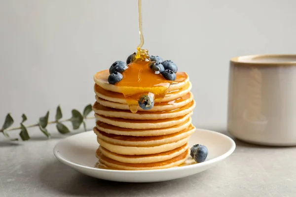 Menuang Madu Pancake Lezat Dengan Buah Berry Atas Meja — Stok Foto