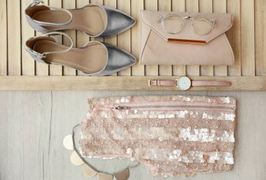 Ahşap arka plan üzerinde kadın için şık kıyafeti ile düz yatıyordu kompozisyon