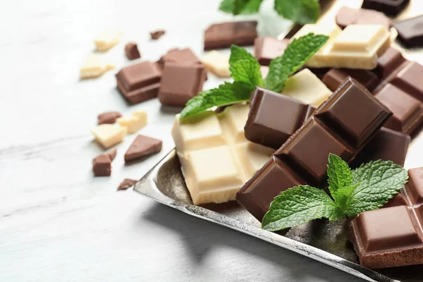 Different kinds of chocolate with mint on light table