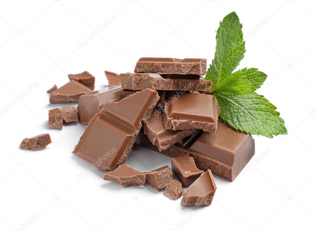 Pieces of milk chocolate with mint on white background