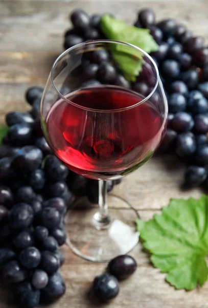 Ποτήρι Κόκκινου Κρασιού Και Νωπά Ώριμα Σταφύλια Ζουμερά Στο Τραπέζι — Φωτογραφία Αρχείου
