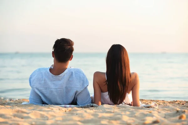 幸せな若いカップルのビーチで一緒に横になっています — ストック写真