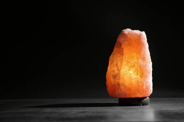 Himalaya tuz lambası siyah arka plan karşı masada. Metin için yer