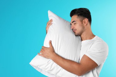 Renk arka plan üzerinde yumuşak yastık ile genç adam