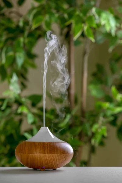 Aroma oil diffuser lamp on table against blurred background