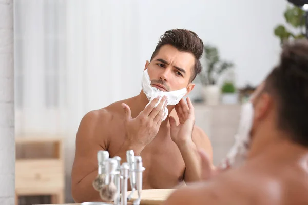 Jovem Aplicando Espuma Barbear Perto Espelho Banheiro — Fotografia de Stock