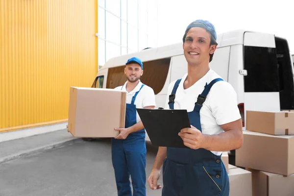 Männliche Mover Mit Box Und Klemmbrett Der Nähe Von Transporter — Stockfoto