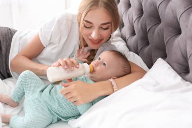 Kadın çocuğunu yatak odasında besleme. Sağlıklı bebek maması