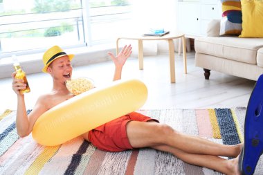 Gömleksiz adam şişme yüzük, içki ve palet katta evde giyiyor patlamış mısır