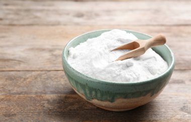 Soda ve ahşap masa üzerinde kepçe pişirme ile kase