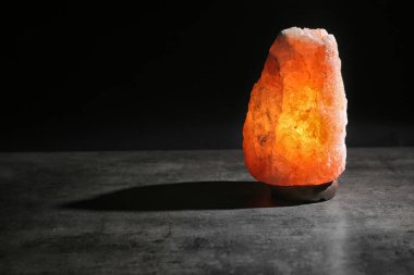 Himalaya tuz lambası siyah arka plan karşı masada. Metin için yer