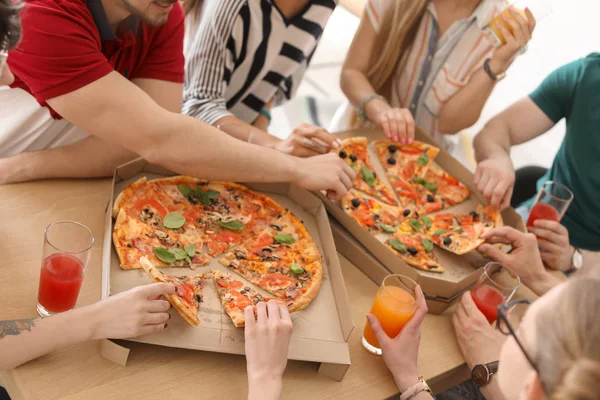 Молодые Люди Едят Вкусную Пиццу Столом Крупным Планом — стоковое фото