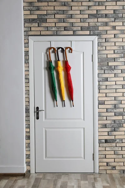 Kolorowe Parasole Wiszące Drzwiach Mur Cegły — Zdjęcie stockowe