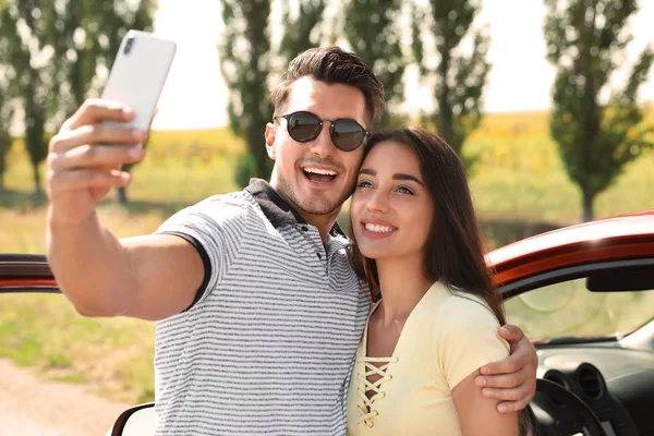 Feliz Joven Pareja Tomando Selfie Cerca Coche Carretera —  Fotos de Stock