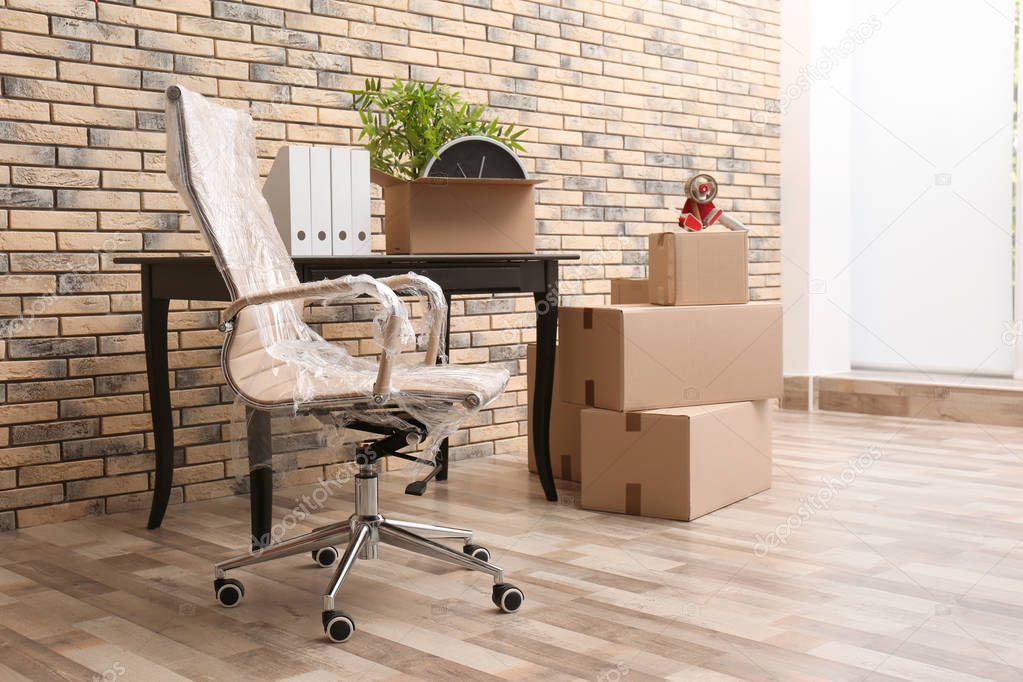 Furniture and moving boxes in empty office