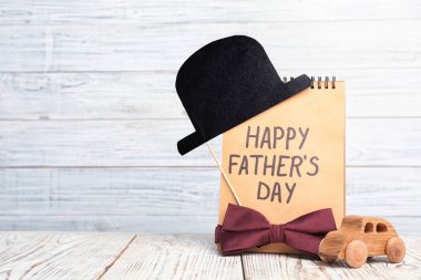 Kağıttan şapka, defter ve papyon metin için yer ahşap tablo. Babalar günü kutlama