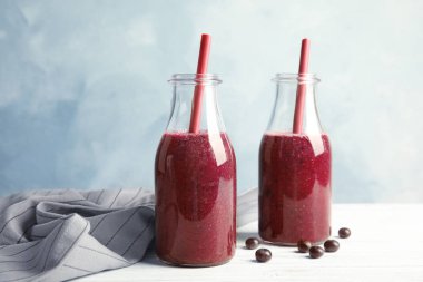 Şişe lezzetli acai smoothie renk arka plan karşı masada ile