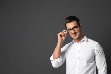 Gri bir arka plana dayanır telefonda konuşurken yakışıklı delikanlı. Metin için yer