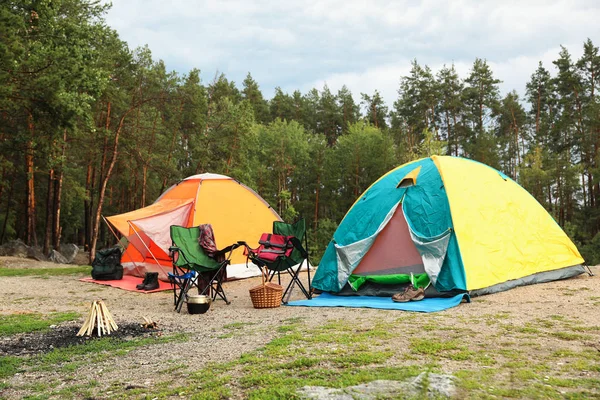 Camping tents and accessories in wilderness on summer day