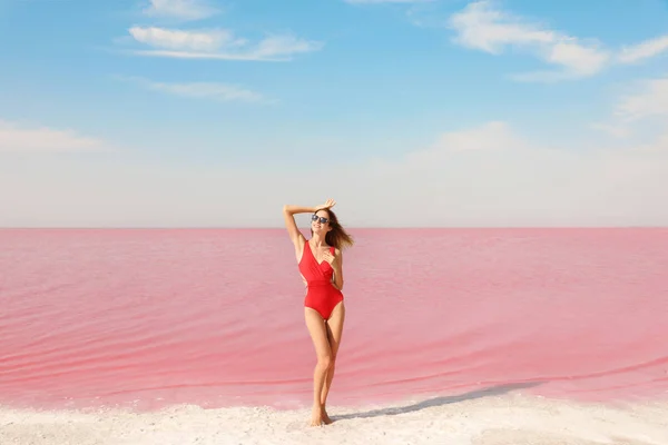Piękna Kobieta Strój Kąpielowy Pozowanie Pobliżu Różowe Jezioro Słoneczny Dzień — Zdjęcie stockowe