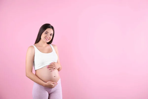 Piękne Kobiety Ciąży Trzymając Się Ręce Brzuchu Przed Kolor Tła — Zdjęcie stockowe