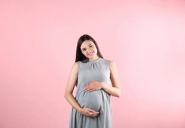 Красивая Беременная Женщина Держит Руки Животе Цветном Фоне — стоковое фото