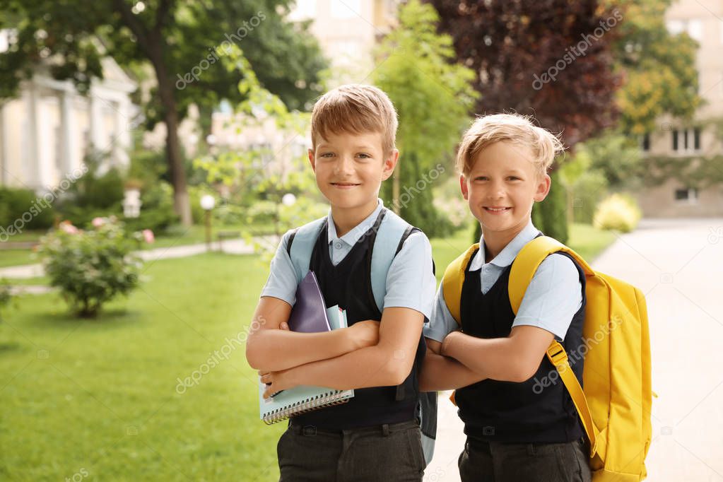 Lindo niño sonriente alumno niña 6-7 años usar uniforme escolar posando en  patk al aire libre mirar la cámara