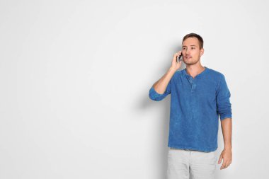 Telefon beyaz arka plan üzerinde konuşan genç adam. Metin için yer