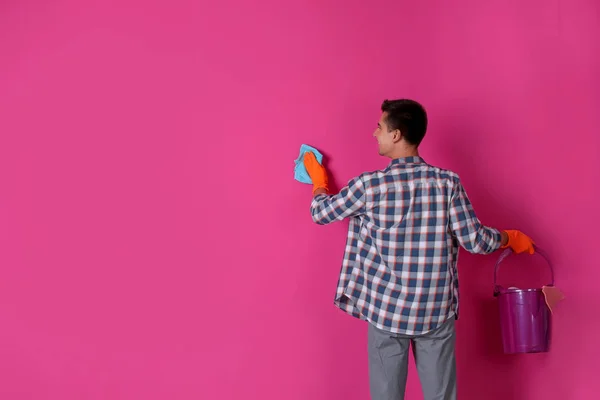 男子手套清洗彩色墙壁与抹布 — 图库照片