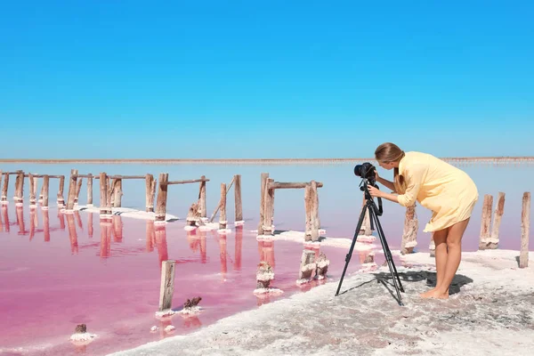 晴れた日にピンクの湖の近くの女性の写真をプロのカメラマン撮影 — ストック写真