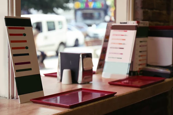 Menu and empty tray on table near window in cafe