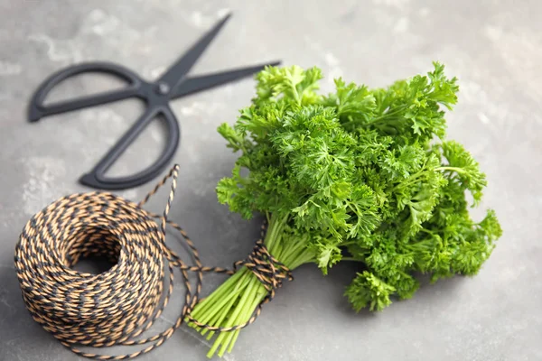 Rope and fresh green parsley on grey background