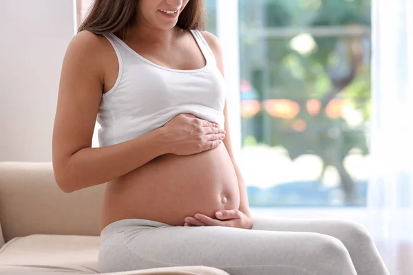 クローズ アップ 自宅のソファーに座っている妊娠中の女性 — ストック写真