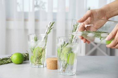 Kadın dökme kireç kokteyl bardak biberiye masada, closeup ile içine