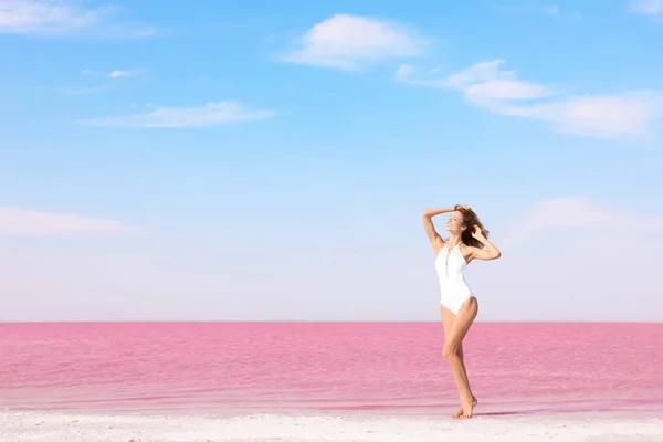 Piękna Kobieta Strój Kąpielowy Pozowanie Pobliżu Różowe Jezioro Słoneczny Dzień — Zdjęcie stockowe
