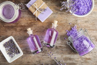 Doğal bitkisel yağ ve lavanta çiçekleri ahşap arka plan üzerinde düz yatıyordu kompozisyonu