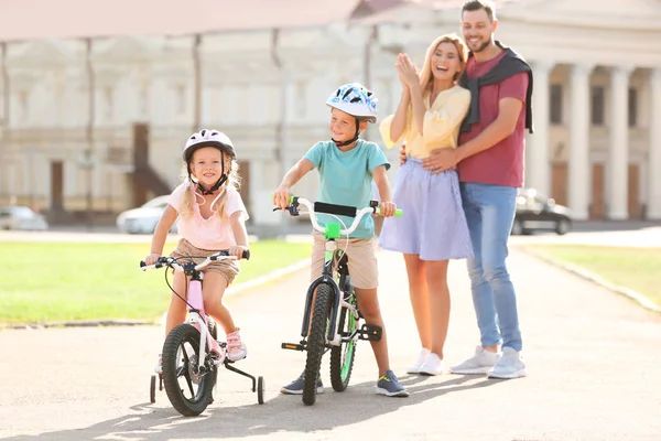 Des Parents Heureux Apprenant Aux Enfants Faire Vélo Extérieur — Photo