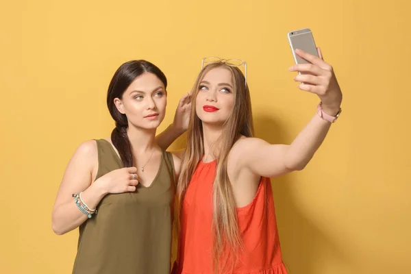 Atractivas Mujeres Jóvenes Tomando Selfie Sobre Fondo Color — Foto de Stock