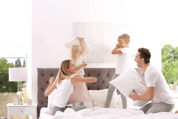 快乐的家庭在床上枕头打架在家 — 图库照片