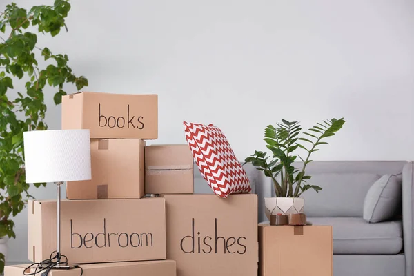 Pile of moving boxes and household stuff in living room