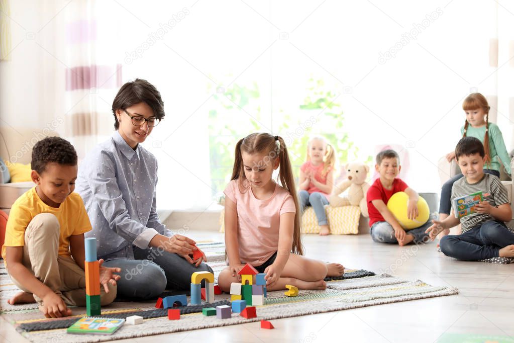 Young woman with little child indoors. Learning by playing